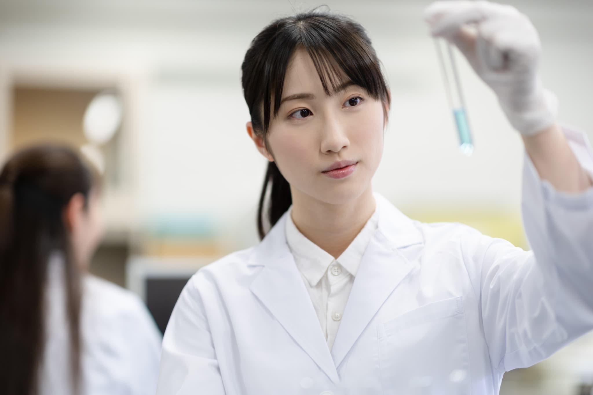 試験管を持つ女性